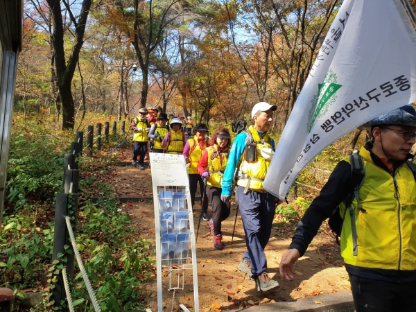 단체 산행팀이 북악산한양도성 탐방안내소 근무자의 계도에 따라 질서정연하고 안전하게 안내소 출입구를 통과하고 있다 (사진= 송영철기자)