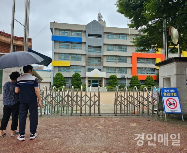 ▲학교앞을 지나가던 시민들이 해당 학교를 바라보며 이야기를 나누고 있는 모습.(사진=권영창기자)