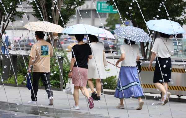 기상청이 올 장마가 27일로 끝났다고 발표한 가운데, 전국에 폭염특보가 발효되며 최고 체감온도가 35도로 올라 무더운 30일 오후 서울 종로구 광화문광장 분수터널에서 시민들이 양산으로 더위를 피하고 있다.  2024.07.30/뉴스핌