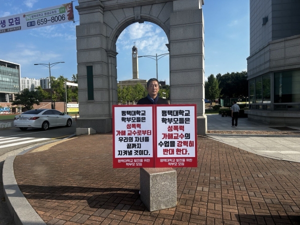 ▲평택대학교 발전을 위한 학부모 모임 관계자가 평택대학교 정문에서 피켓을 들고 있다.(사진=평택대학교 학부모 제공)