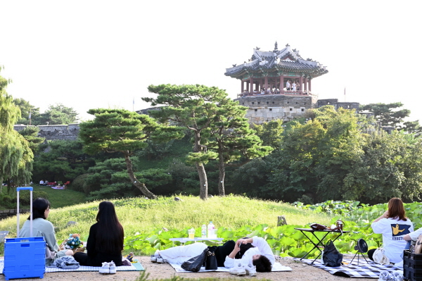 시민들이 수원화성 방화수류정이 보이는 용연에서 가을 피크닉을 즐기고 있다.(사진=수원특례시)